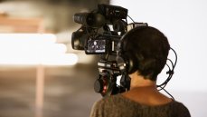 Blick über die Schulter einer Kamerafrau: Per Intercom-System sind die Kameraleute jederzeit akustisch mit der Bildregie verbunden. Außerdem zeigt ihnen ein rotes Licht an, ob ihre Kamera gerade auf Sendung ist. (Foto: Samuel Groesch)